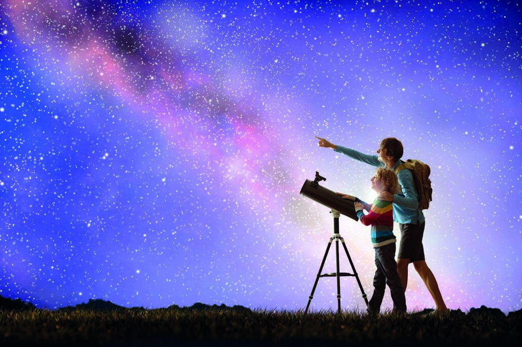 Deux personnes observent le ciel la nuit grâce à un téléscope